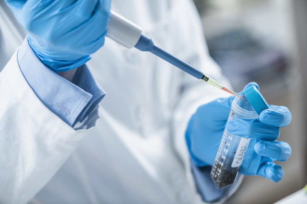 Échantillon de terre prélevé à la pipette dans un tube, en laboratoire d'analyse
