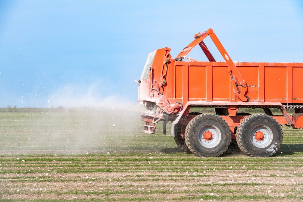 Epandage de la marne grâce un épandeur atteler sur un tracteur